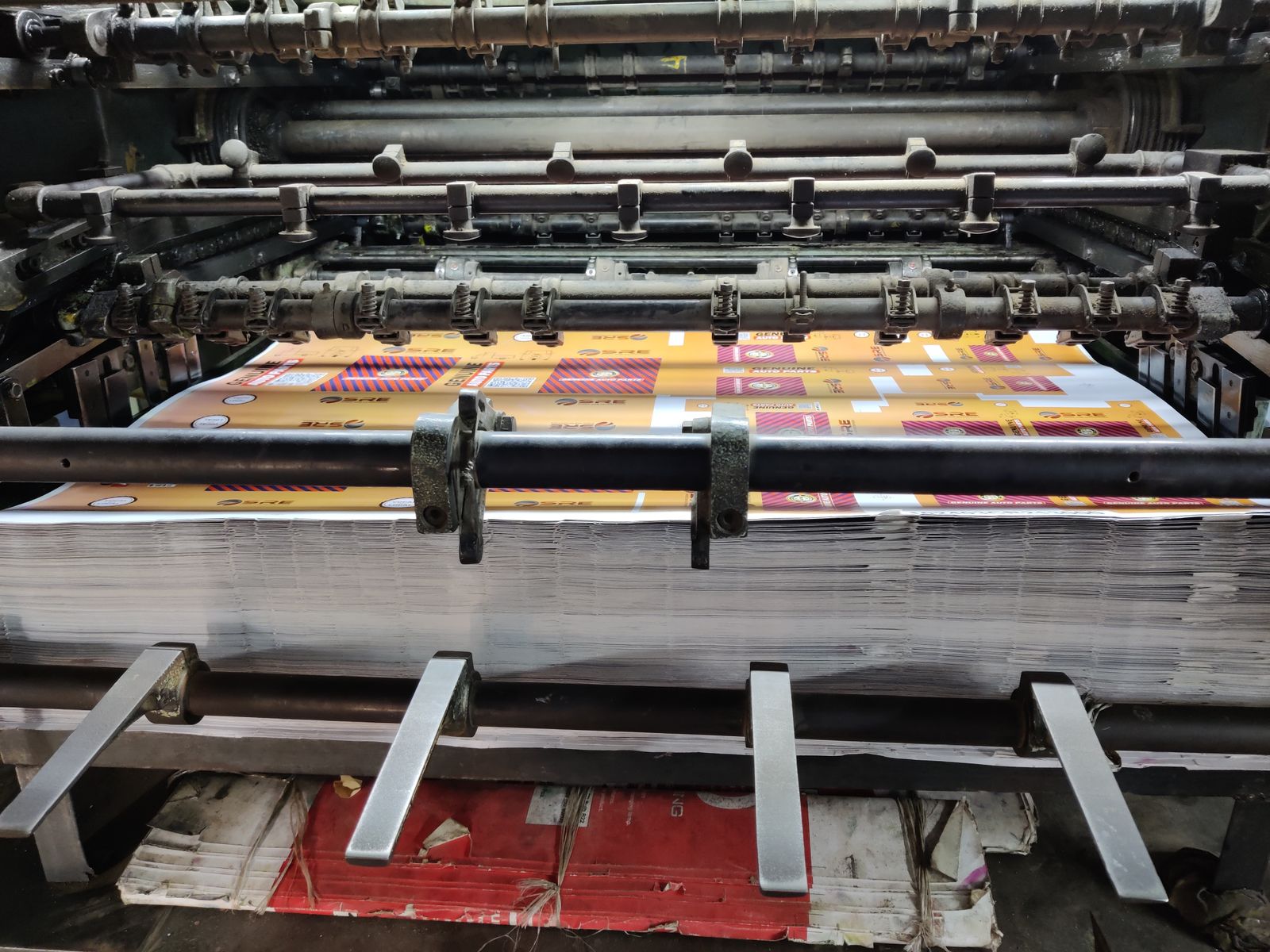 Paper sheets being processed by an industrial printing machine.